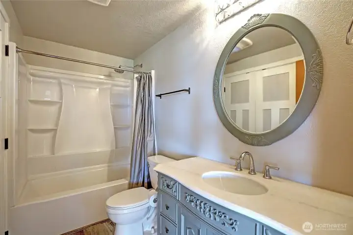 Tastefully updated bathroom with the washer and dryer in the utility closet