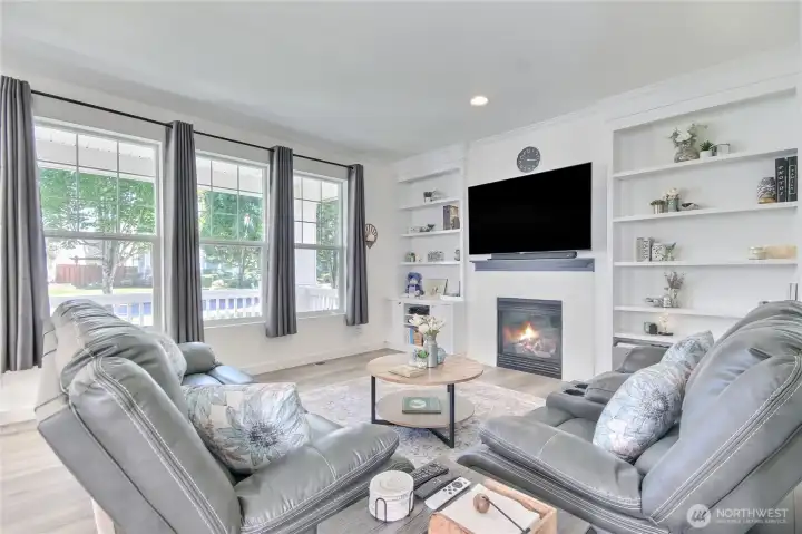 Wonderful living room with gas fireplace & custom built-in bookcases & cabinets on each side along with  beautiful LVP flooring thruout. Big windows let in lots of natural light.