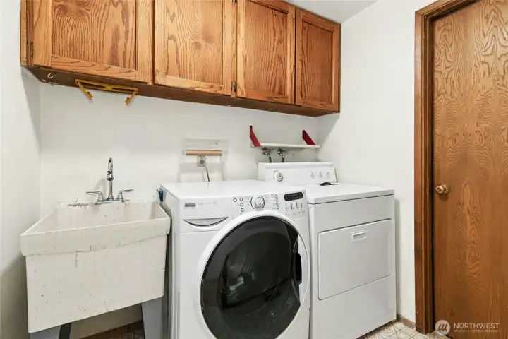 Laundry area features a sink and cabinetry, and is located on the main level. Laundry area features a sink and cabinetry, and is located on the main level.