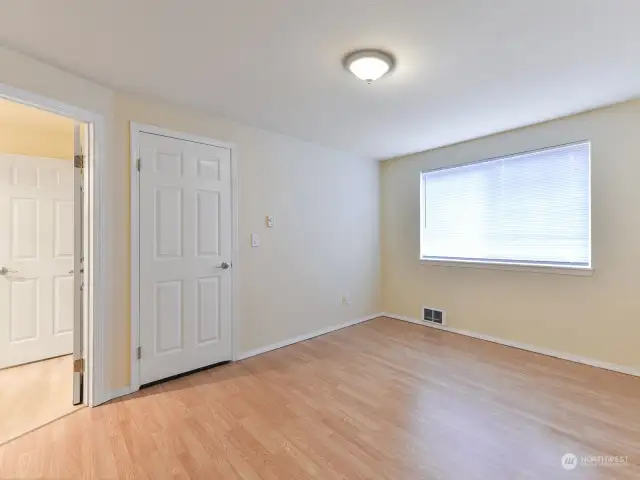 Another view of primary, large window, newer laminate flooring