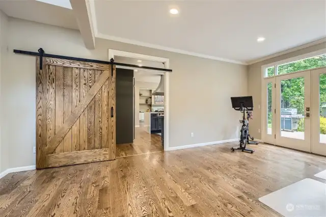 A barn door separates the huge office from the kitchen/greatroom. You'll find two built-in desks, cabinetry, a closet and French doors to the back deck in this office.