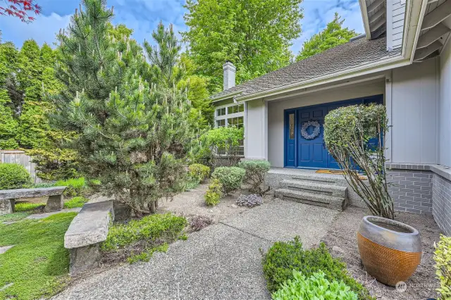 A welcoming entrance to the double front door with stone benches to sit and enjoy the impeccable landscaping.