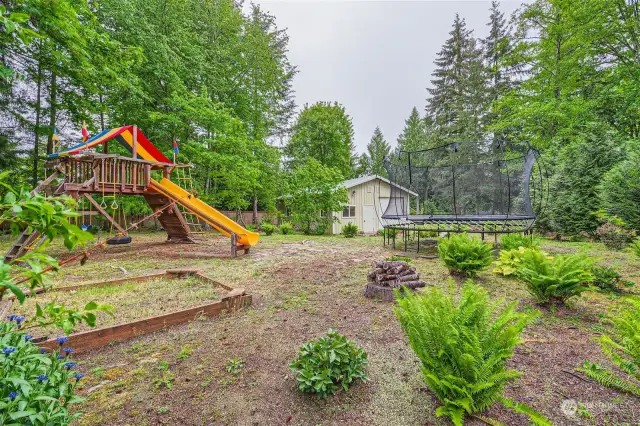 Play structure and workshop in parklike backyard