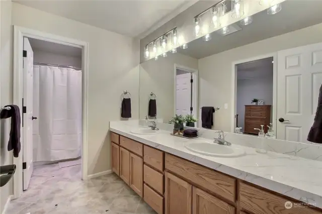 Updated full bath features new quartz countertops & new lighting and lots of cabinets!