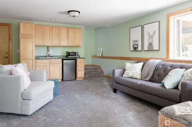 Downstairs family/entertainment room with TV and wet bar with a mini fridge and microwave. Hot tub is right outside this room.