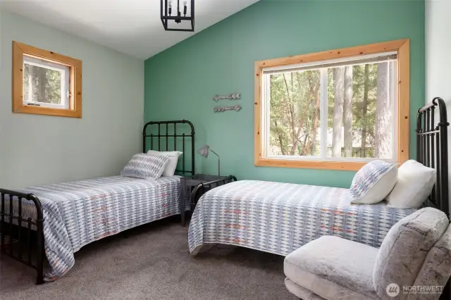 Upstairs bedroom featuring two twin beds, vaulted ceiling and two windows. (Bedroom #2)