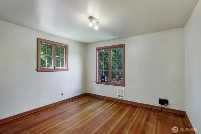 Front bedroom with pine hardwood floors, cedar lined closet and 2 large classic windows.