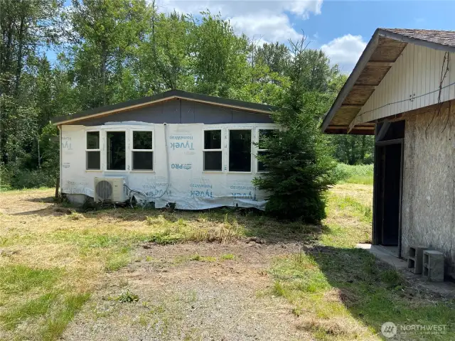 Facing south at old manufactured home with shed on the right.