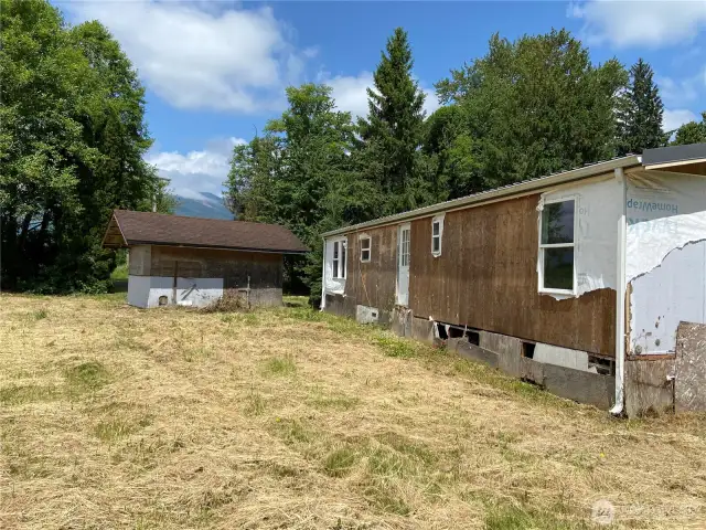West side of old manufactured home and shed. Facing north.