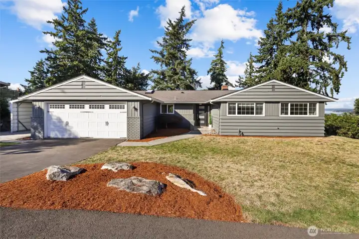 Front of home with dramatic lake and city skylines behind