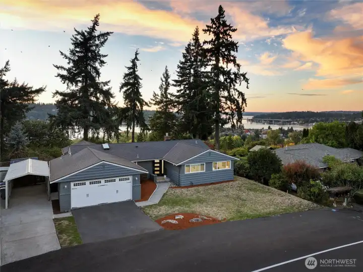 Front home with dramatic lake and city skylines behind