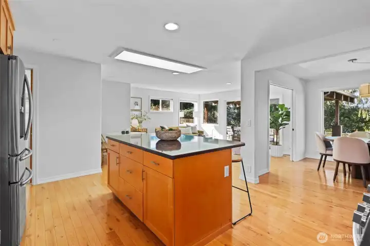 Updated timeless design kitchen with natural wood shaker cabinets, stainless steel appliances and large island with seating