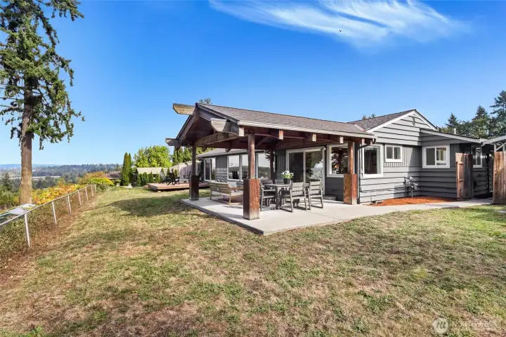 Backyard with multiple entertaining areas including covered patio