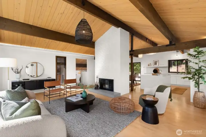 Looking from the SE corner of the room towards the wood burning fireplace and open kitchen. The fireplace provides just enough separation between these rooms.