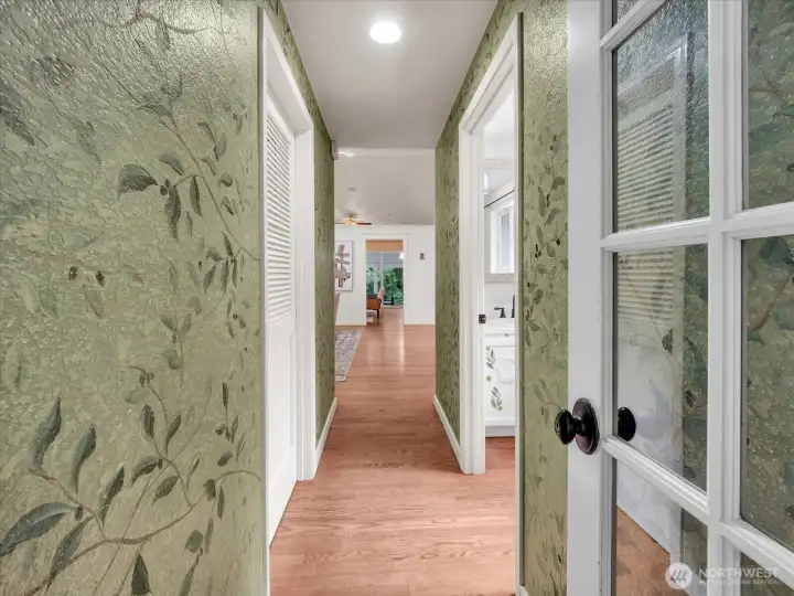 Charming hallway with botanical accent walls and wood floors