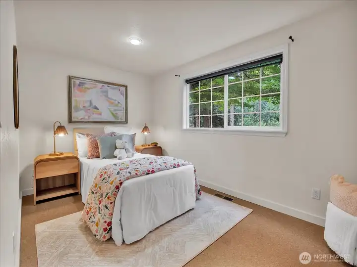 Bright guest bedroom with large window and garden views