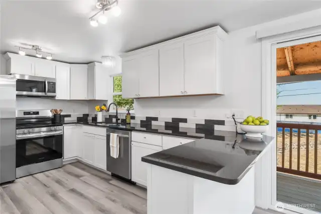 Quality white cabinetry, granite counters, tiled backsplash, stainless appliances
