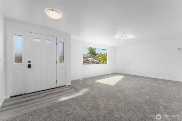 Bright and spacious living room with abundant natural light, new carpeting, fresh paint