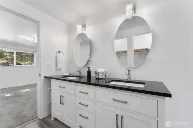 Elegant main-floor primary bedroom with en-suite bath boasting double sinks with granite counters, jetted walk-in tub, designer lighting, and a generous closet