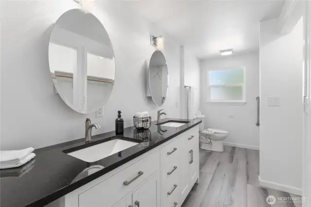 Sophisticated en-suite retreat with jetted walk-in tub, dual granite vanities, and upscale designer finishes