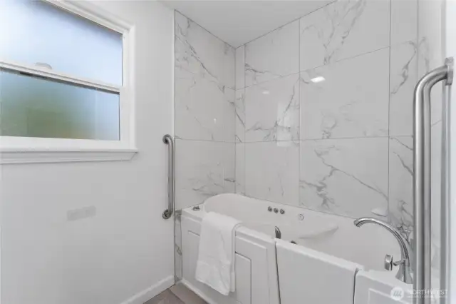 Unwind in this spa-style en-suite with fully tiled, jetted walk-in tub, dual granite sinks, and designer finishes