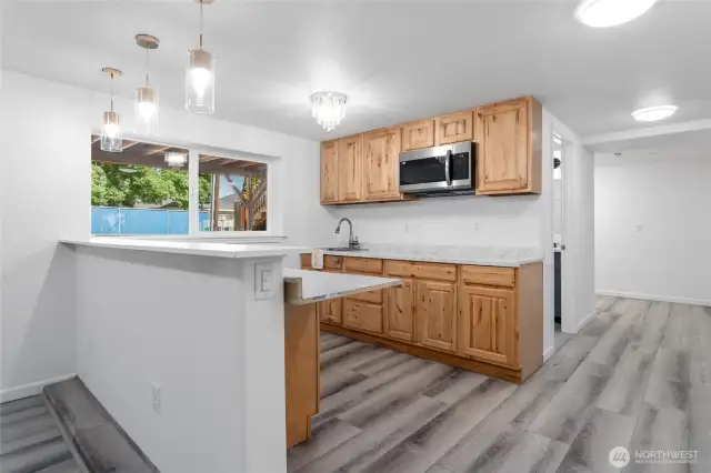 Lower level includes a second kitchen, two bedrooms, expansive family room, utility and storage rooms, a bathroom and private entrance