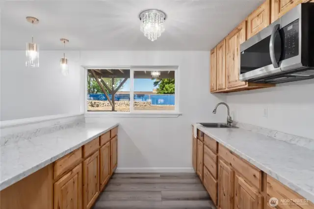 Versatile lower level ideal for multi-generational living or rental income—featuring a second kitchen, two bedrooms, expansive family room, utility space, bathroom, storage, and a private entrance