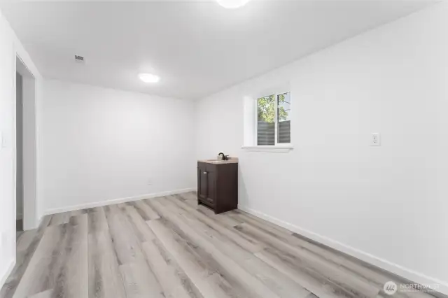 Spacious lower-level bedroom with sink—one of two bedrooms on this level. This room is perfect for a hobby room!