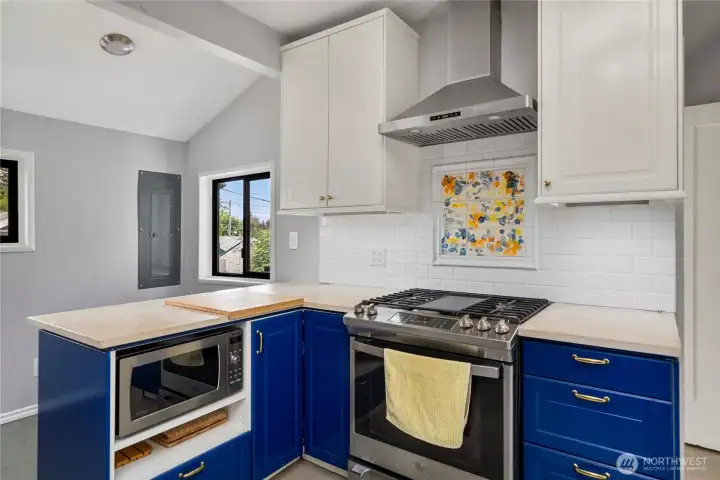Cooking corner of kitchen, gas stove and excellent counter space.