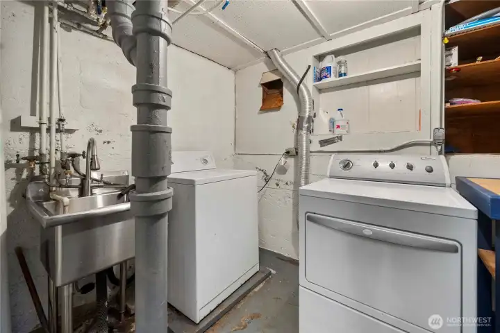 The laundry area boast a newer stainless steele sink and lots of storage space and area for folding clothes