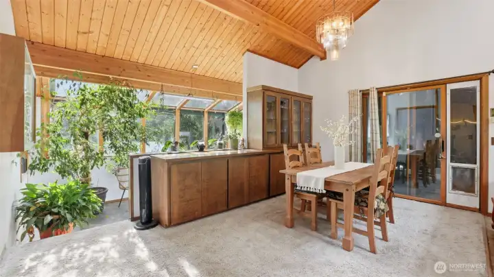 Spacious dining area with built-in buffet and solarium overlooks backyard.