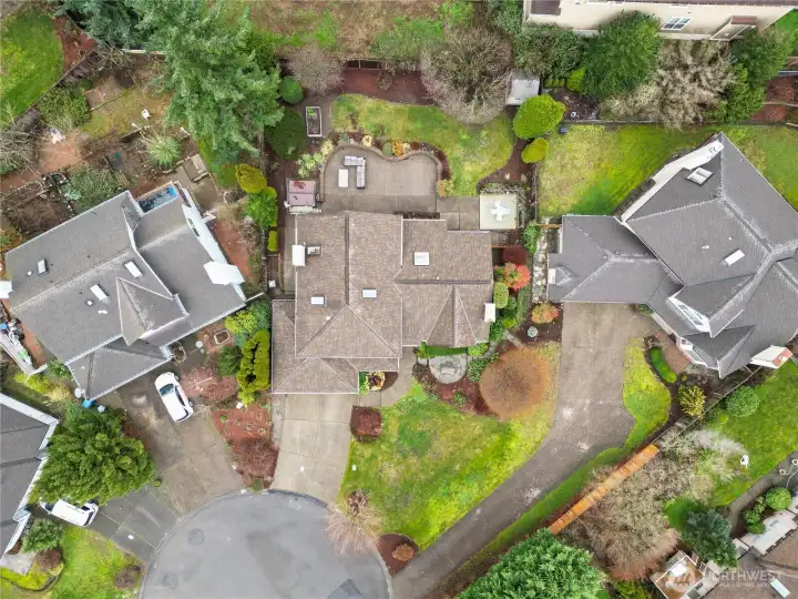 An overhead drone sharing the expansive backyard including patios, garden space, hot tub and more.
