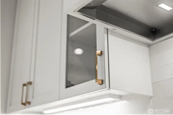 Detail shot of specialty under-cabinet lighting illuminating quartz countertops and custom cabinetry, highlighting the upgraded designer kitchen finishes in this newer construction McCormick Trails home.
