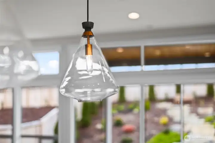 Custom pendant lighting highlights the upgraded designer kitchen and dining spaces, showcasing elevated finishes and thoughtful detail throughout this newer construction home in McCormick Trails, Port Orchard.