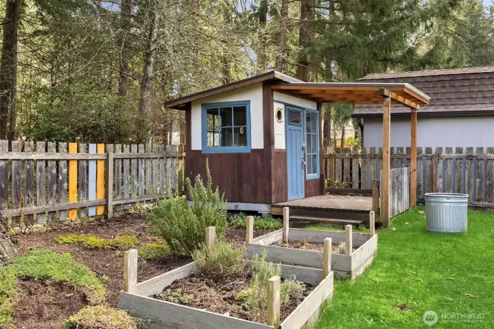 Fully fenced back yard complete with raised garden beds, shed with windows and sprinkler system for easy maintenance