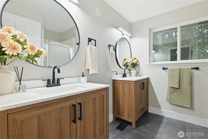 Primary suite with en suite bath featuring a double vanity, walk in shower, and toilet