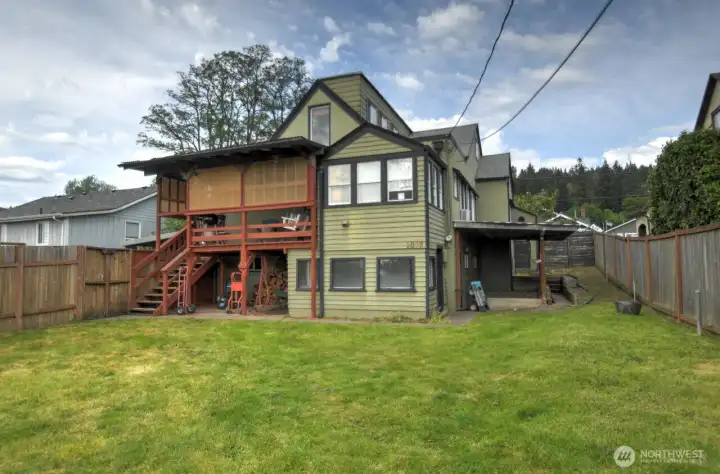 Spacious backyard retreat featuring a covered upper deck, mature landscaping, and plenty of room for entertaining, gardening, or pets. The fully fenced yard offers privacy and flexibility, while the additional storage add everyday convenience.