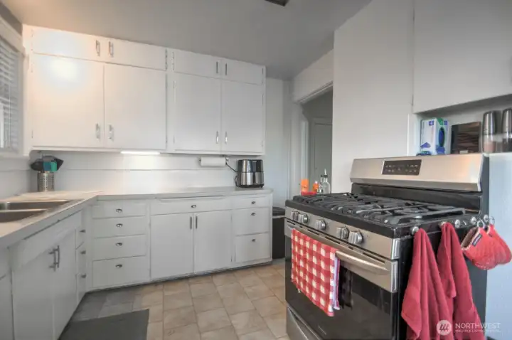 Bright and functional kitchen featuring ample cabinet storage, generous counter space, and a stainless gas range perfect for everyday cooking and entertaining.