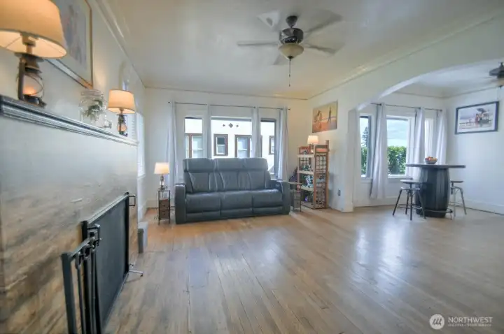 Open and inviting living space with beautiful hardwood floors, abundant natural light, and a seamless flow into the dining area—perfect for relaxing or entertaining.