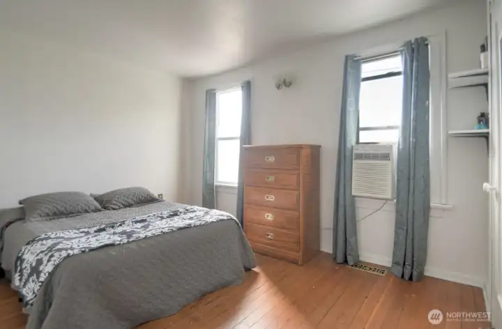 Comfortable main floor bedroom featuring hardwood floors, natural light, and convenient access for easy everyday living.