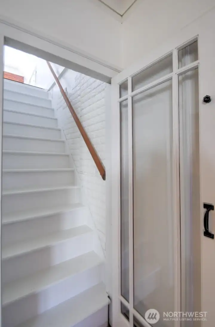 Classic staircase with charming architectural details leading to the upper level, adding timeless character to the home.