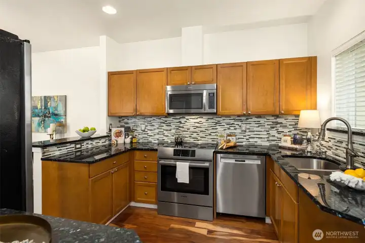 To the right of the front door is this stylish kitchen with granite and stainless appliances. Down the hall is a pantry for extra food storage.