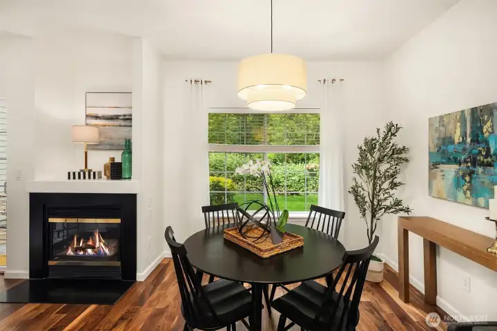 The dining area is overlooks the grassy yard area and is flanked by the gas fireplace.