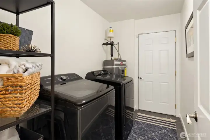 The washer and dryer remain with the home, as does the shelving unit next to it. The water heater is new as of 2024 and that door leads to your private garage.