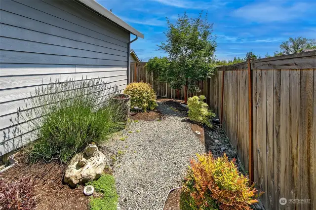 Lush landscaped backyard is fully fenced.