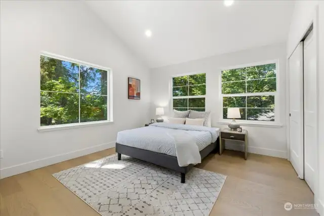 Oversized, 12x15' primary bedroom.  Vaulted ceilings and windows on 3 sides fill this space with natural light.  Plenty of space for additional seating.