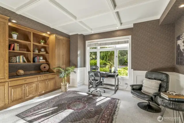 The office or study is off the foyer and features a wall of built-in cabinetry, wainscoting and tray ceiling.