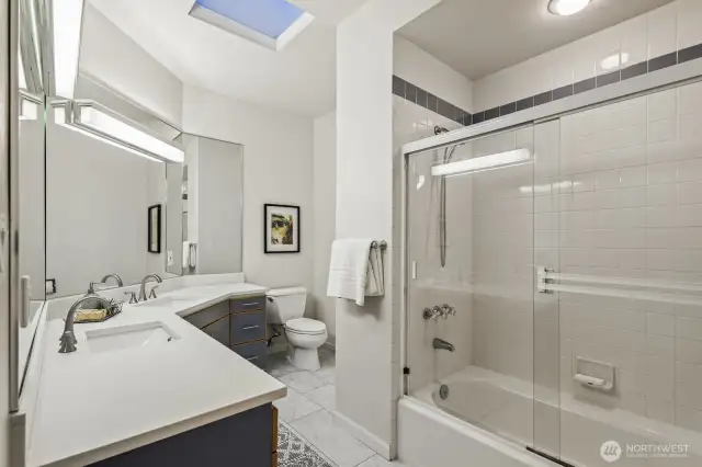 Upstairs hall bathroom with tiled floors and quartz vanity.