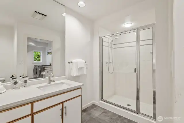 3/4 bathroom with a quartz vanity conveniently located for those who like to work in the yard, kids rolling in the mud or soiled dogs that need hosing off.