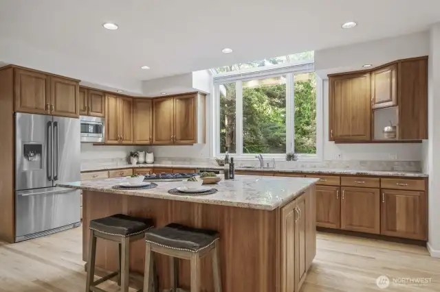 Cherry cabinetry with a natural finish, slab granite counters and tumbled marble back splash.